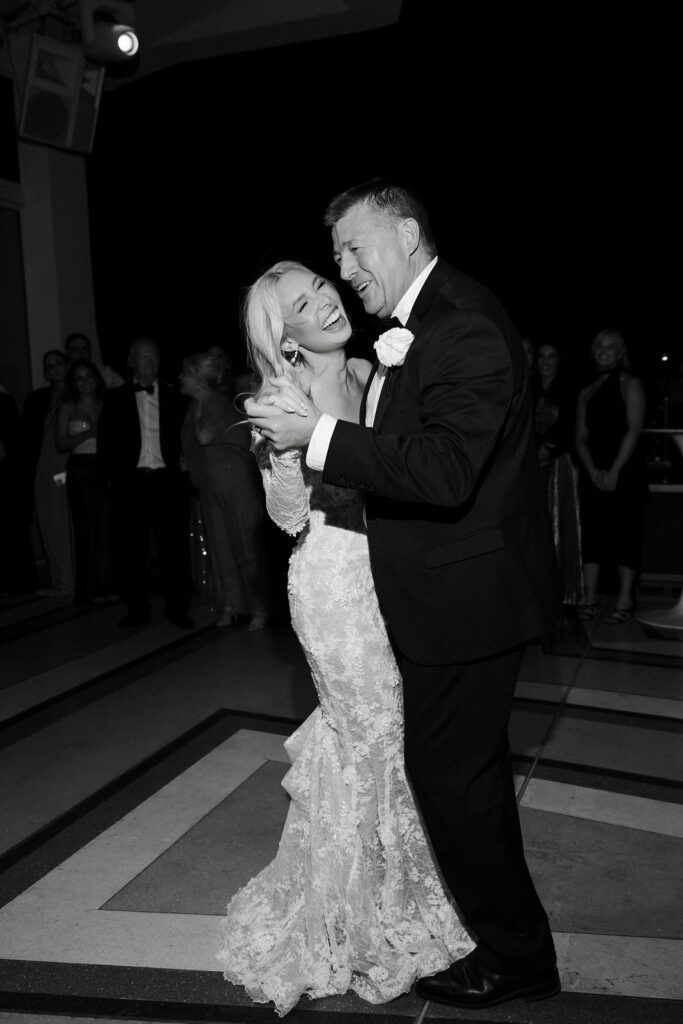 Black and white photo of the bride dancing on the rooftop.