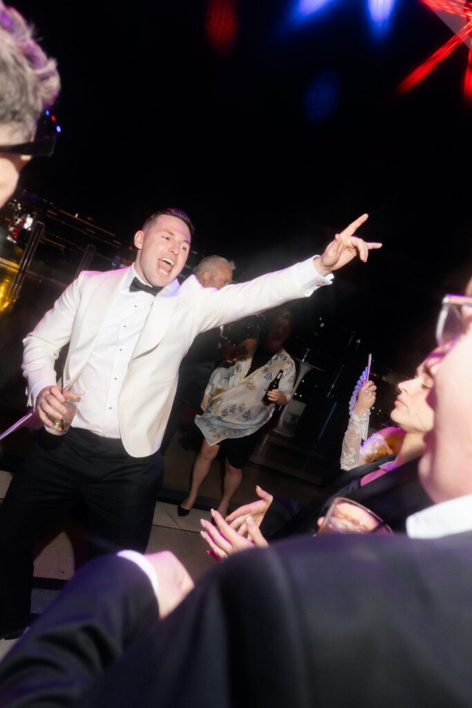 Groom dancing with guests during his rooftop Ghostbar at The Palms Las Vegas wedding reception.