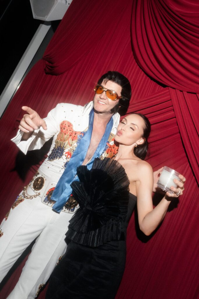 Elvis impersonator Travis Allen Elvis posing with a guest.