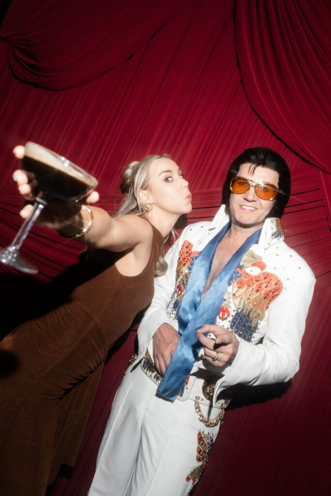 Elvis impersonator Travis Allen Elvis posing with a guest.