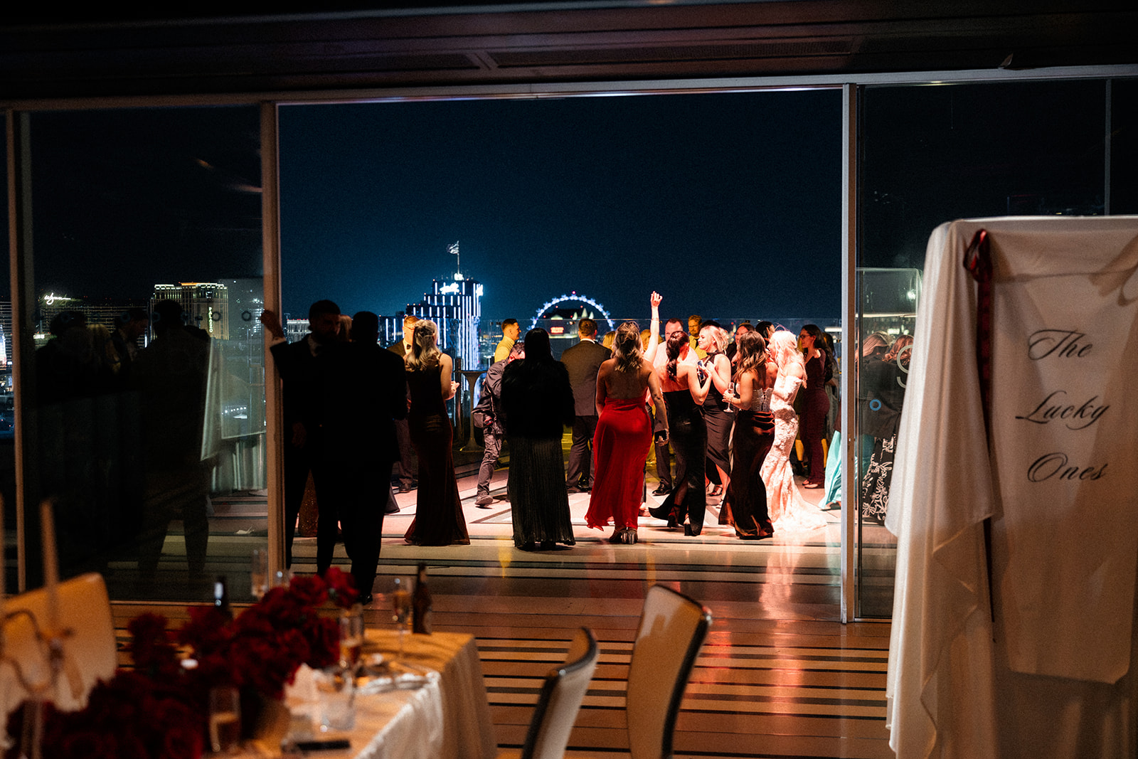 Guests dancing on the rooftop at night in Las Vegas for a wedding reception at Ghost Bar at The Palms.