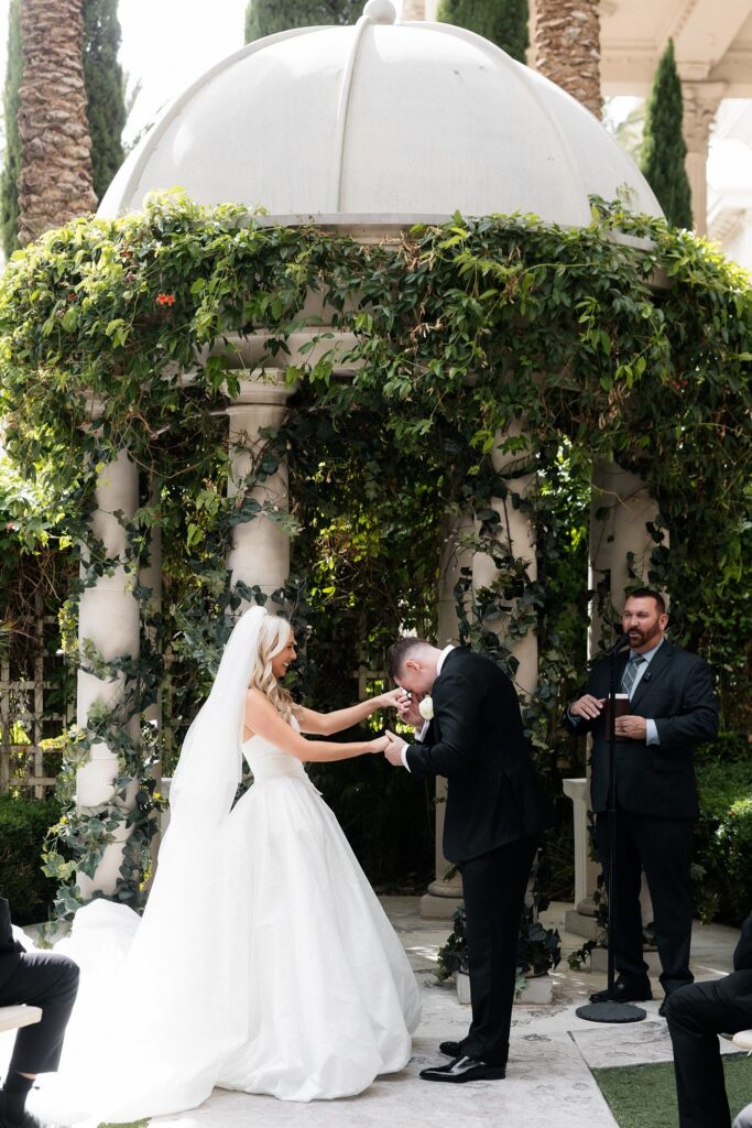 Groom kissing the brides hand during their Las Vegas wedding at Venus Garden Caesars Palace.