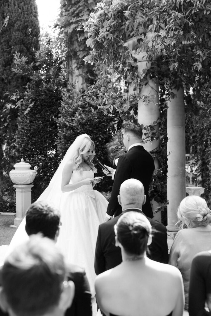 Black and white photo of a bride and groom reading vows to each other during their Venus Garden Caesars Palace wedding in Las Vegas.