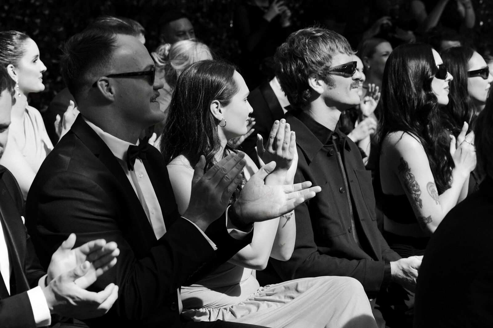 Wide shot of guests clapping during a ceremony.