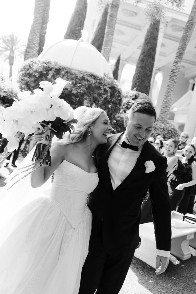 Black and white photo of a bride and groom walking back down the aisle as husband and wife after their Venus Garden Caesars Palace wedding ceremony.