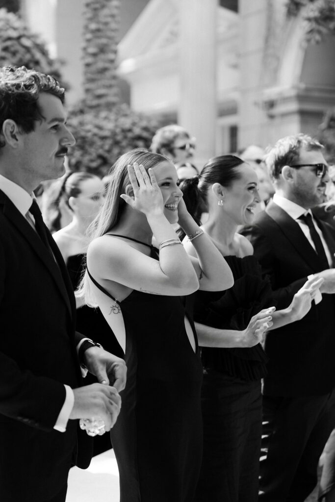 Black and white photo of guests reacting happily after a ceremony.