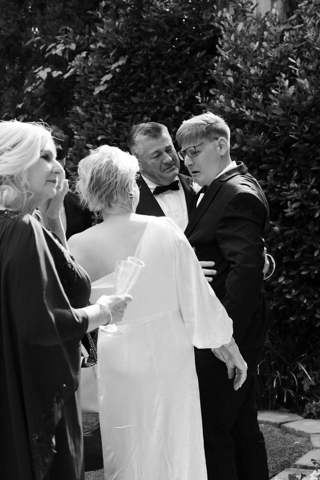 Black and white photo of guests getting emotional after a ceremony.