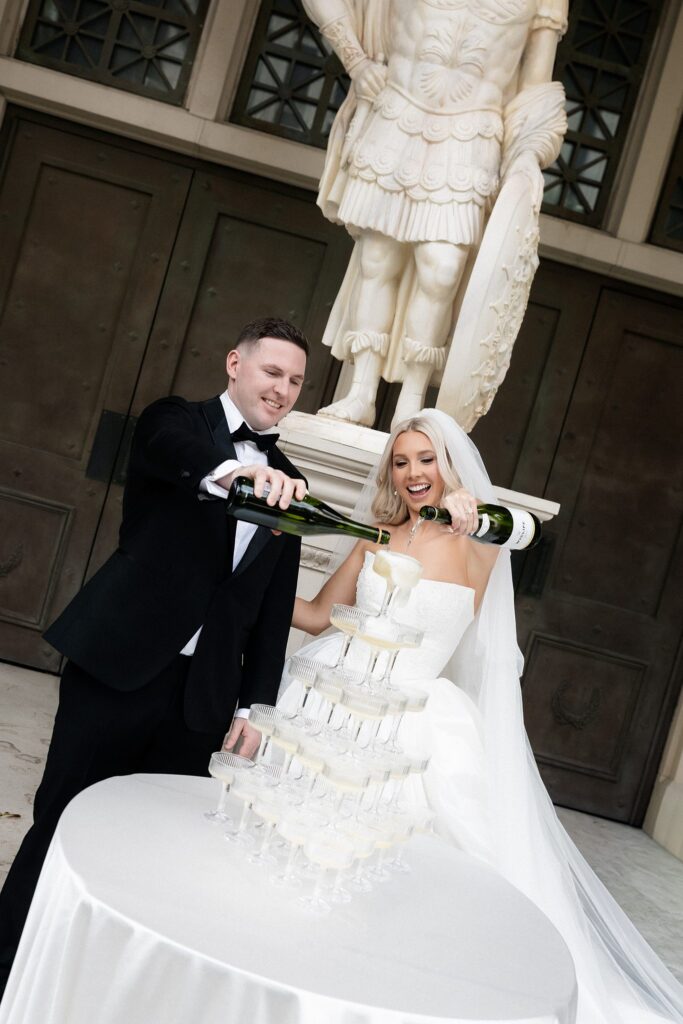 Bride and groom pouring champagne into their champagne tower. 