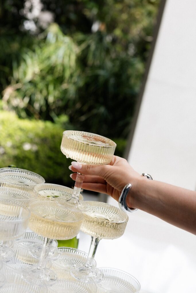 Guest grabbing a glass of champagne off of the champagne tower.
