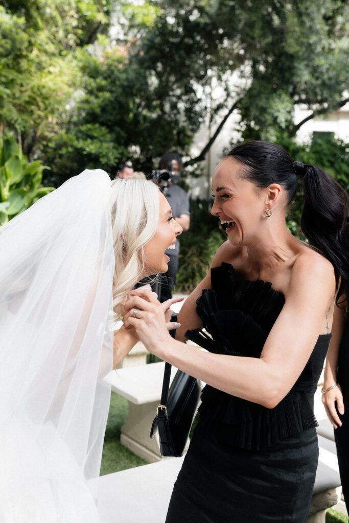 Bride and friend reacting excitedly after the ceremony.