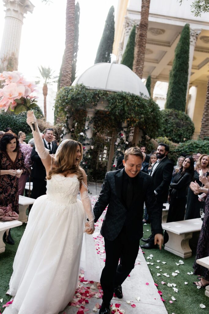 Bride and groom walking back down the aisle as husband and wife after their Caesars Palace Venus Garden wedding ceremony.