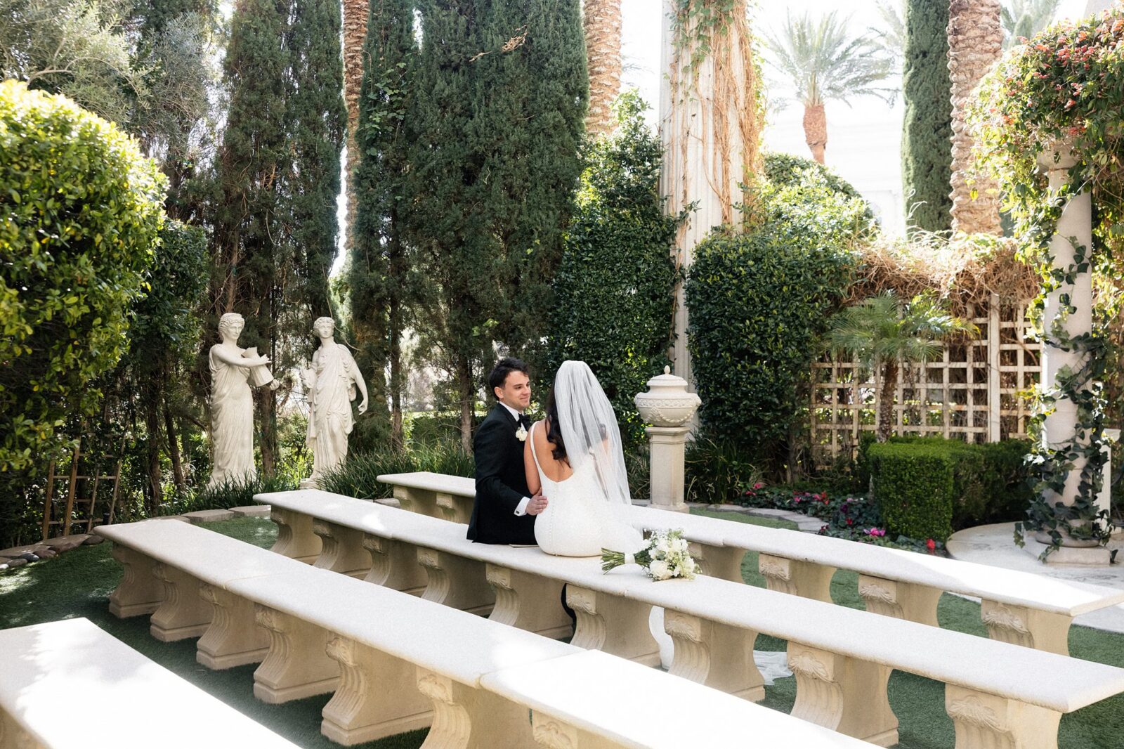 Bride and  groom sharing an intimate moment sitting on the benches at Venus Garden Caesars Palace.