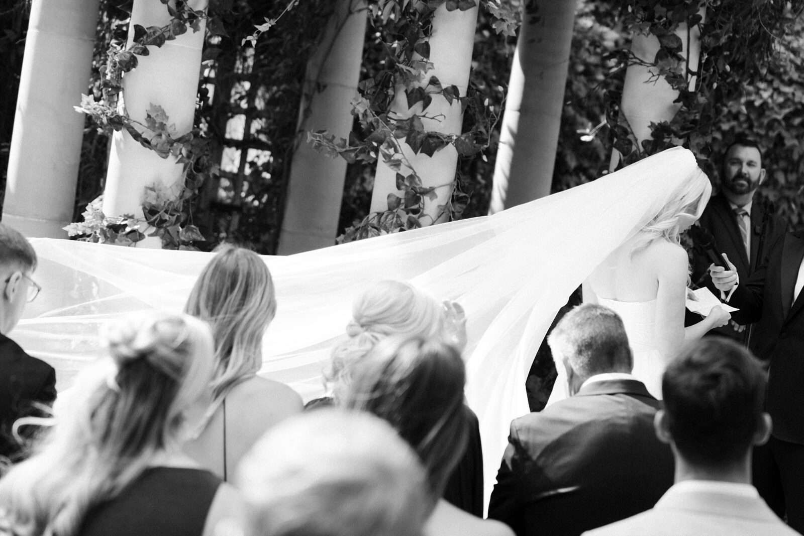 Black and white photo of a bride reading her vows during her ceremony.