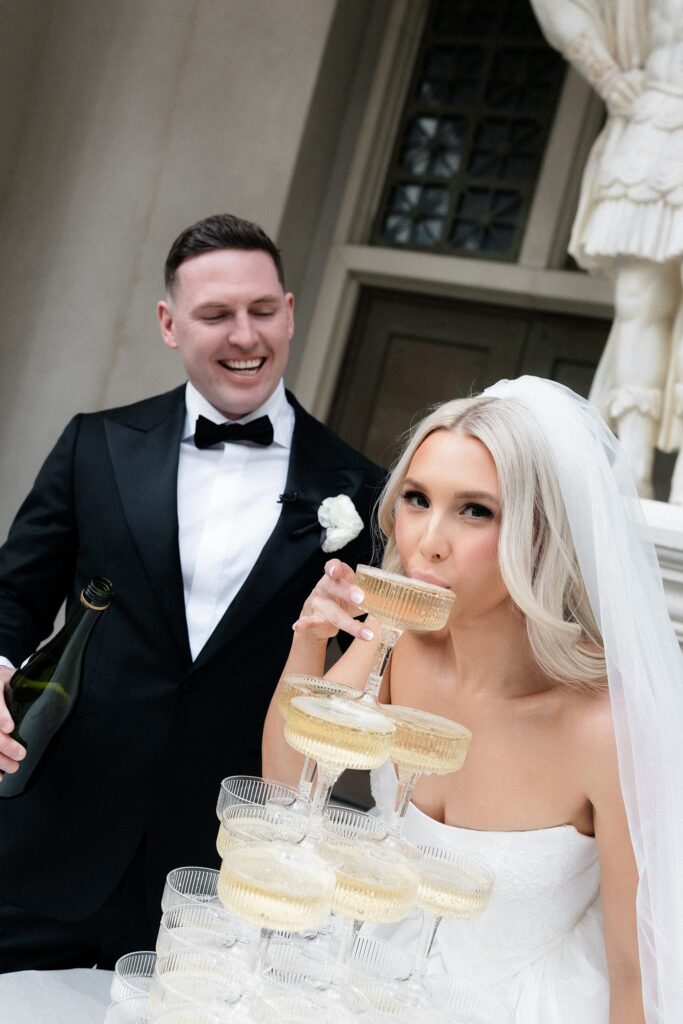 Bride and groom taking a drink of champagne from their champagne tower at Venus Garden Caesars Palace.