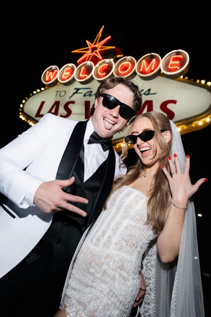 Couple posing in front of the Welcome to Fabulous Las Vegas sign at night for their wedding photos.