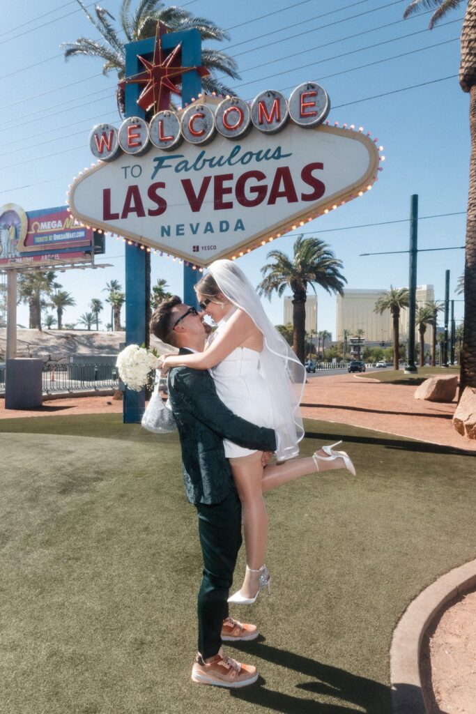 Man picking up his bride during their Las Vegas wedding photos.