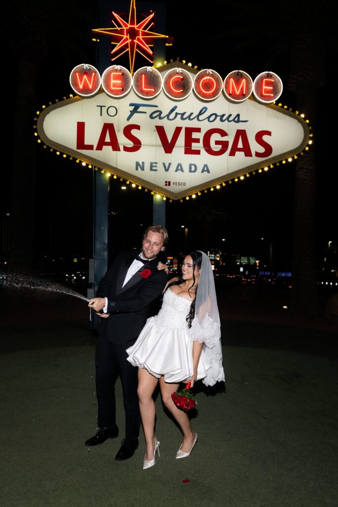 Couple popping champagne during their Las Vegas elopement.